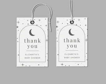 May include: Two white thank you tags with a crescent moon and stars design. The text on the tags reads "thank you" and "Elizabeth's Baby Shower".