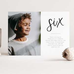 Puede incluir: Una invitaci&oacute;n de cumplea&ntilde;os con una foto de un ni&ntilde;o peque&ntilde;o con un gorro gris y una camisa a rayas. La invitaci&oacute;n dice "Six" en letra cursiva negra e incluye los detalles de la fiesta: fecha, hora, lugar e informaci&oacute;n de RSVP.