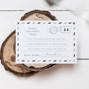 May include: A white gift certificate with black and gray accents. The text reads "Happy Christmas Mum! This coupon entitles you to a spa treatment at The Willow followed by lunch at The Ivy. Love from: Hannah xo"