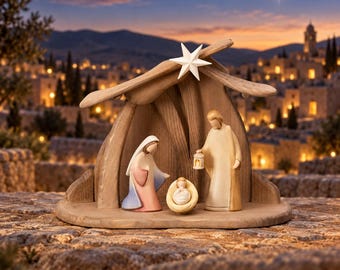 May include: A wooden nativity set featuring three stylized figures under a simple shelter topped with a white star. One figure wears a blue and pink robe, another holds a small lantern, and a central figure rests in a small cradle.