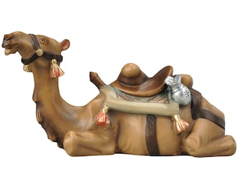 May include: A brown wooden camel figurine lying down with a saddle and a bag of gold coins. The camel has a brown leather bridle with red tassels.