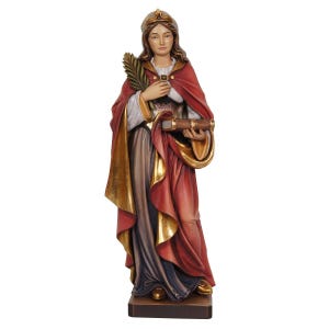May include: A wooden statue of a woman wearing a red and gold robe and a crown. She is holding a book and a palm branch.