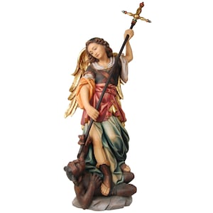 Op de afbeelding: Een houten beeld van een engel met gouden vleugels, staande op een demon. De engel houdt een speer vast met een kruis erop. De engel draagt een kleurrijke robe en de demon draagt een zwarte en bruine robe.
