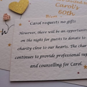 May include: A card with gold glitter accents and the text "60th" and "Carol's 60th". The card also includes the text "Carol requests no gifts. However, there will be an opportunity on the night for guests to donate to a charity close to our hearts. The charity continues to provide professional support and counselling for Carol."