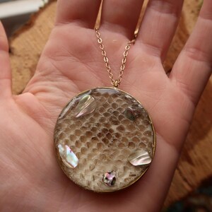 Hanger van geperste balpythonslangenhuid en abaloneschelp in goud