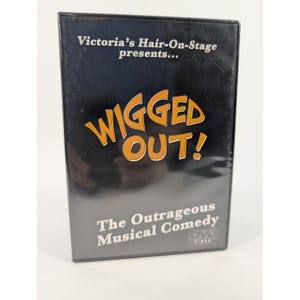 Puede incluir: Una caja de DVD negra con el título "WIGGED OUT!" en letras naranjas y amarillas. El texto "Victoria's Hair-On-Stage presents..." está encima del título. Debajo del título está "The Outrageous Musical Comedy" y el logotipo de DVD.