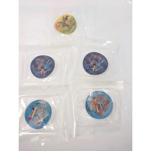 Könnte beinhalten: Eine Sammlung von Sammelscheiben mit Cartoon-Charakteren, jeweils in einem transparenten Plastikbeutel versiegelt. Die Scheiben zeigen farbenfrohe Illustrationen verschiedener Charaktere, darunter Bugs Bunny.