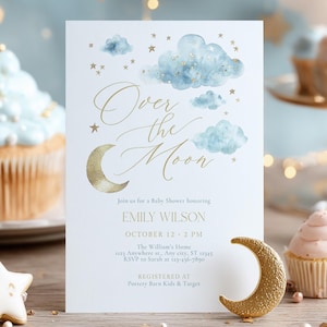 Può includere: Un invito per un baby shower con il testo "Over the Moon" e i dettagli per la festa di Emily Wilson. L'invito presenta nuvole ad acquerello e dettagli dorati. Sono presenti anche una luna crescente dorata e un biscotto a forma di stella.