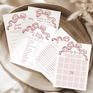 May include: Baby shower game cards in pink and burgundy, featuring games like "Guess Baby", "Guess Who, Mummy or Daddy?", "The Price is Right", and "Baby Bingo". Each card is decorated with a burgundy bow design.