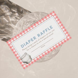 Op de afbeelding: Een luierloterijkaart met een rood-witte ruitjesrand. De kaart heeft de woorden "DIAPER RAFFLE" in blauw, instructies en een ruimte voor een naam. Een aquarel illustratie van een luier staat in de hoek.