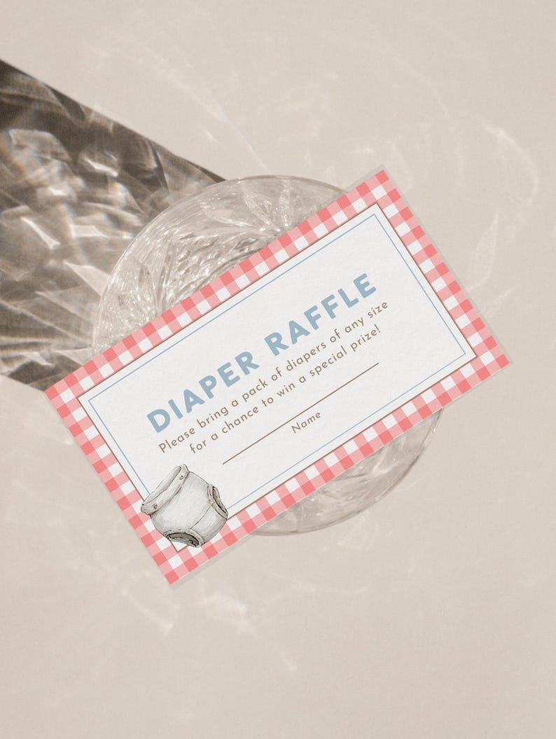 Op de afbeelding: Een luierloterijkaart met een rood-witte ruitjesrand. De kaart heeft de woorden "DIAPER RAFFLE" in blauw, instructies en een ruimte voor een naam. Een aquarel illustratie van een luier staat in de hoek.