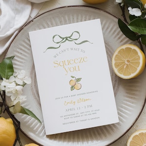 May include: A baby shower invitation with the text "We can't wait to squeeze you" in gold and green. The invitation features a lemon theme with illustrations and real lemons. The invitation is on a white background.