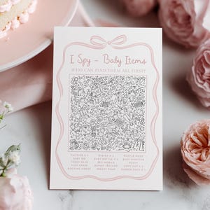 Pu&ograve; includere: Un biglietto per il gioco del baby shower con il testo "I Spy - Baby Items". Il biglietto ha un bordo rosa e un fiocco in alto. Il centro del biglietto &egrave; pieno di illustrazioni in bianco e nero di oggetti per bambini. La parte inferiore del biglietto elenca gli oggetti da trovare.
