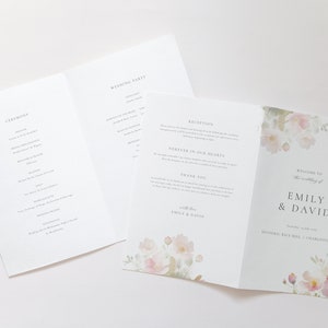 May include: A wedding program with a floral design. The front cover features the text "Welcome to the wedding of Emily & David" and the date "September 10, 2023". The back cover features a watercolor floral design with pink and green flowers.