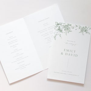 Peut inclure: Un programme de mariage avec un motif floral dans des tons de vert. Le programme comprend les détails de la cérémonie et de la fête de mariage. La couverture avant indique "Bienvenue au mariage d'Emily & David" et comprend la date et le lieu : "18 novembre 2023 | Historic Rice Mill | Charleston, SC."