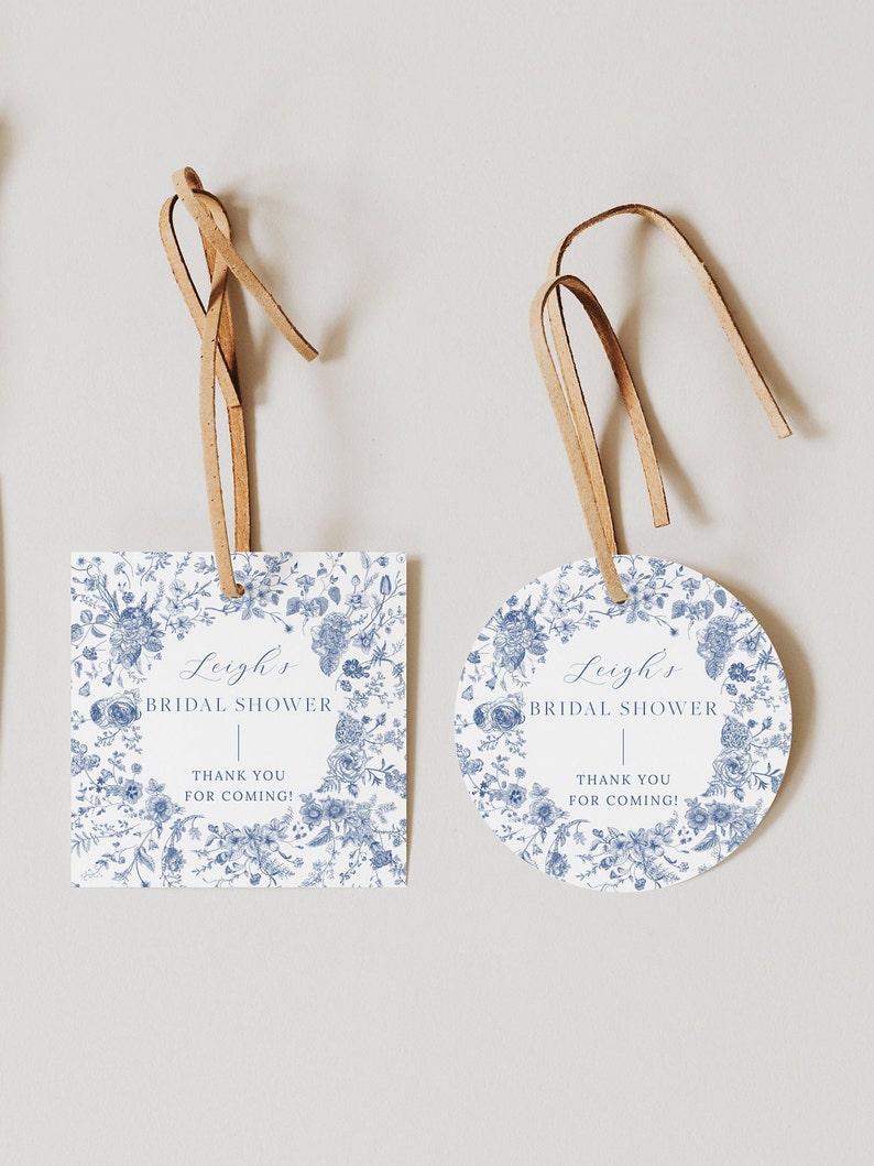 May include: Two blue and white floral patterned bridal shower favor tags. One tag is rectangular and the other is round. Both tags have the text "Leigh's Bridal Shower" and "Thank you for coming!" printed on them.