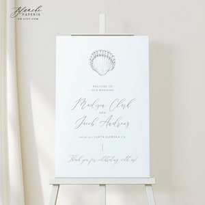Könnte beinhalten: Ein weißes Hochzeitsschild mit einer Muschel-Illustration und dem Text "Willkommen zu unserer Hochzeit, Madison Clark und Jacob Andrews, 08.06.11 Santa Barbara, CA, Vielen Dank, dass Sie mit uns feiern!"