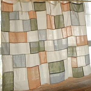 Peut inclure: Un rideau en patchwork composé de panneaux rectangulaires dans des tons sourds de vert sauge, d'orange poussiéreux et de bleu clair, alternant avec des panneaux blancs à fines rayures verticales. Le rideau est suspendu par des nouettes.