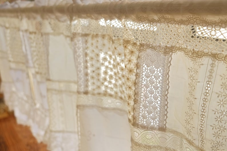Puede incluir: Una cortina de encaje blanco con un dise&ntilde;o de patchwork. El encaje est&aacute; hecho de diferentes patrones y texturas, creando un aspecto &uacute;nico y elegante.