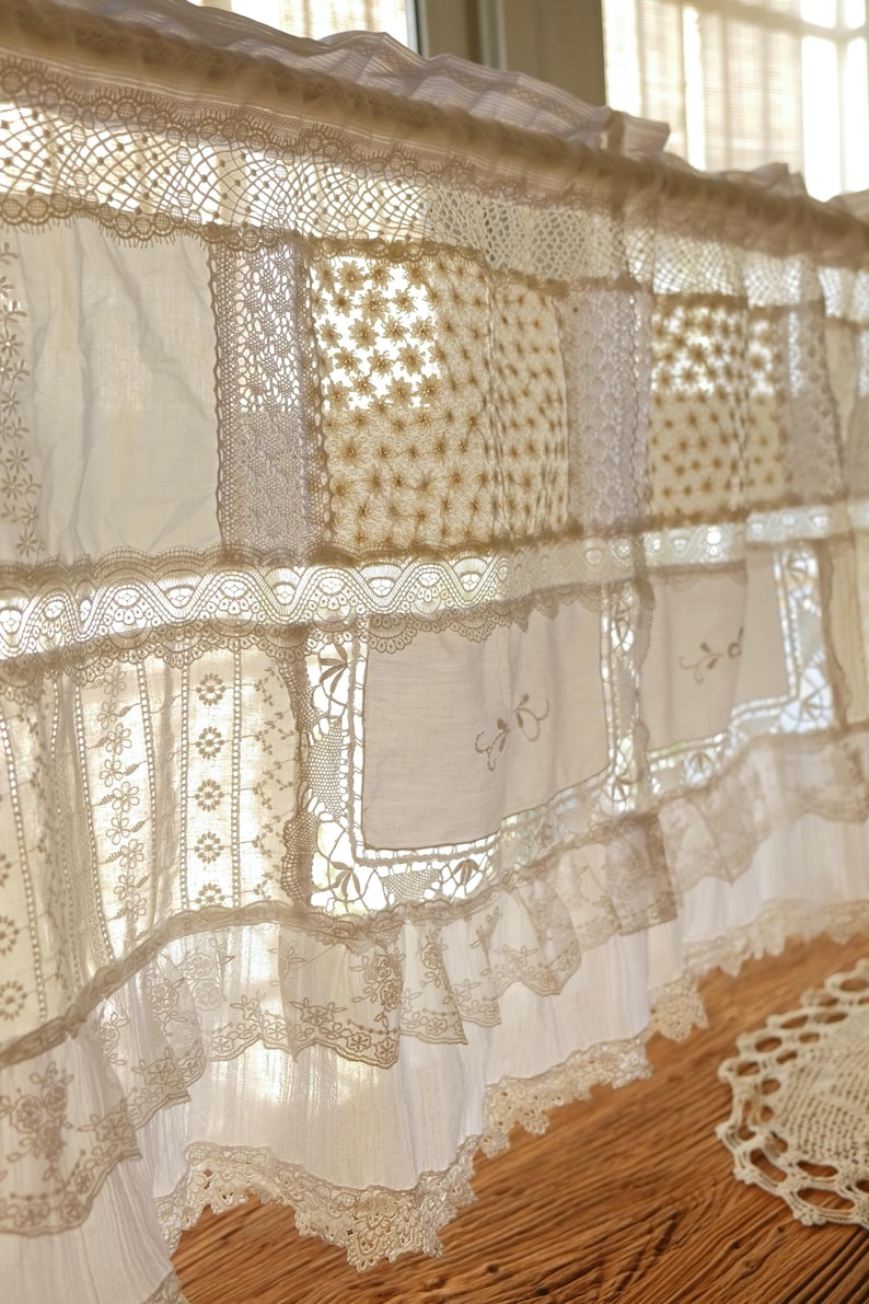 Puede incluir: Una cenefa de encaje blanco con un dise&ntilde;o de patchwork. La cenefa est&aacute; hecha de diferentes tipos de encaje, incluyendo encaje de ojal, encaje de ganchillo y encaje bordado. La cenefa est&aacute; adornada con un volante.