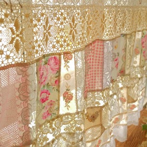 Peut inclure: Une cantonnière patchwork blanche et crème avec une bordure en dentelle. La cantonnière est faite de différents tissus, dont un imprimé floral, du vichy et de la dentelle. C'est un ajout magnifique et unique à toute cuisine ou salle à manger.