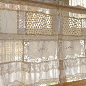 Puede incluir: Cortinas blancas de encaje con un dise&ntilde;o de patchwork. Las cortinas est&aacute;n hechas de diferentes tipos de encaje, incluyendo encaje de ganchillo y encaje bordado. Las cortinas est&aacute;n colgadas en una ventana y dejan entrar la luz natural.