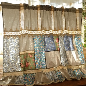 May include: A patchwork curtain featuring floral patterns in blue, green, and pink. The curtain has a brown top with lace trim and a ruffled bottom edge. The curtain is made of multiple fabric panels with a variety of textures.