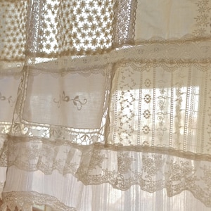 Puede incluir: Cortina de encaje blanco con un dise&ntilde;o de patchwork. El encaje est&aacute; hecho de diferentes patrones y texturas, creando un aspecto delicado y rom&aacute;ntico.
