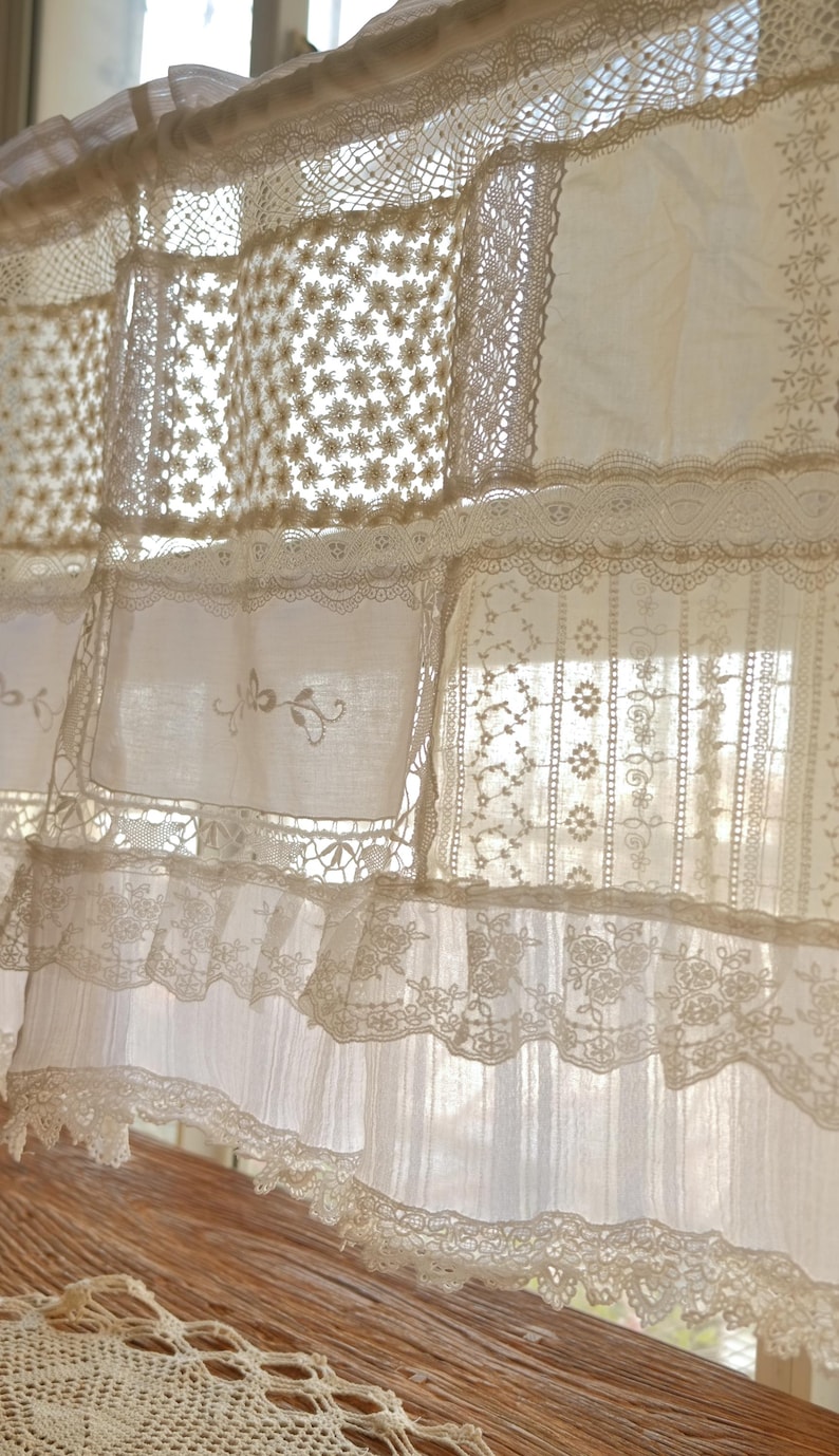 Puede incluir: Cortina de encaje blanco con un dise&ntilde;o de patchwork. El encaje est&aacute; hecho de diferentes patrones y texturas, creando un aspecto delicado y rom&aacute;ntico.