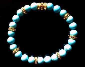 May include: Turquoise beaded bracelet with gold and clear rhinestone accents.