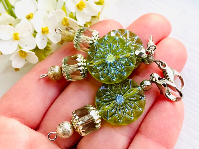 May include: Green glass earrings with a snowflake design and silver beads and clasps.