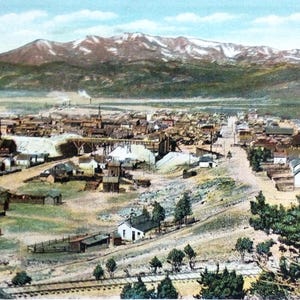 Op de afbeelding: Vintage ansichtkaart met een landschap van Leadville, Colorado, met Mt. Massive op de achtergrond. De tekst op de ansichtkaart geeft de hoogte van Leadville aan als 3.091 meter en de hoogte van Mt. Massive als 4.390 meter. De ansichtkaart vermeldt ook dat Leadville een van de grootste mijnbouwkampen was.