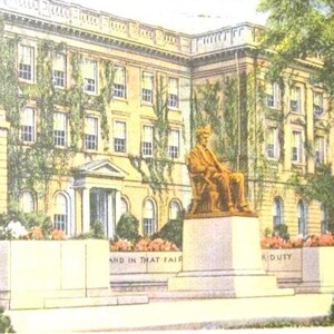 May include: Vintage postcard featuring the Lincoln Monument at Bascom Hall, U. of W., Madison, Wisconsin. The image shows a seated bronze statue in front of a large building with ivy. The postcard has text at the top and bottom.
