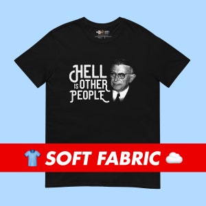 Può includere: T-shirt nero con una stampa grafica bianca di un viso maschile e il testo "L'inferno sono gli altri".