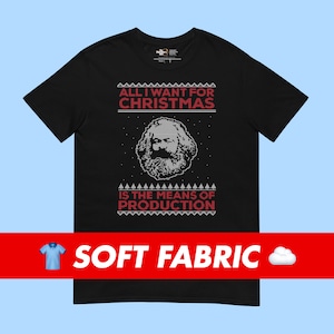 May include: Black t-shirt with a festive design. The shirt features the text "ALL I WANT FOR CHRISTMAS" above a pixelated image of Karl Marx, and the text "IS THE MEANS OF PRODUCTION" below. The shirt has a soft fabric.