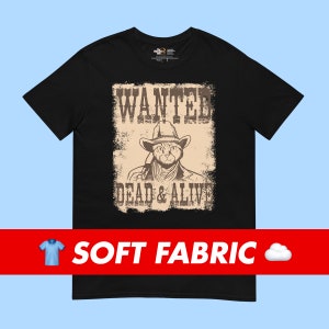 Op de afbeelding: Zwart T-shirt met een vintage-stijl gezochtposter met een kat die een cowboyhoed draagt en de tekst "WANTED DEAD & ALIVE".