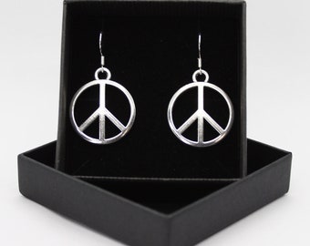 May include: A pair of silver peace sign earrings in a black gift box.