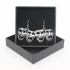 May include: Silver earrings with four silver masks, each with a different facial expression, in a black velvet box.