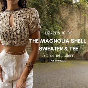 Peut inclure: Un pull beige à manches courtes en crochet avec une encolure en trou de serrure et une fermeture à bouton. Le texte indique : LIZARD&HOOK THE MAGNOLIA SHELL SWEATER & TEE A crochet pattern PDF DOWNLOAD. Porté avec un pantalon blanc.