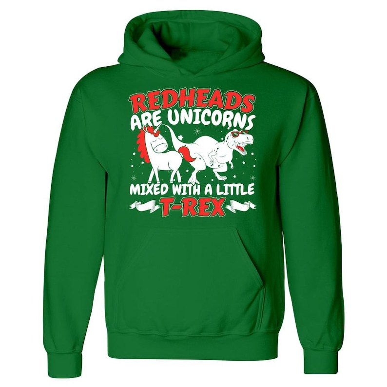K&ouml;nnte beinhalten: Gr&uuml;ner Kapuzenpullover mit einem wei&szlig;en Einhorn und einem roten T-Rex-Motiv. Der Text lautet "Rothaarige sind Einh&ouml;rner, die mit einem kleinen T-Rex vermischt sind."