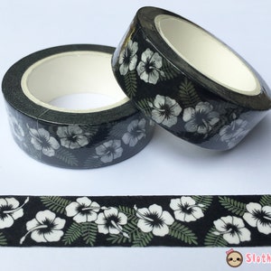 Op de afbeelding: Zwart-witte washi tape met een bloemenpatroon. De tape heeft witte hibiscusbloemen en groene bladeren op een zwarte achtergrond.