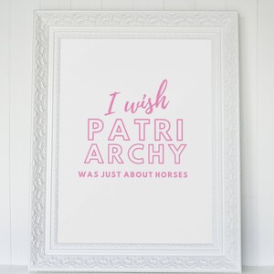 Peut inclure: Une impression encadr&eacute;e blanche avec le texte "I wish patriarchy was just about horses" en lettres roses.