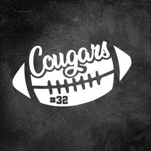 May include: White silhouette of an American football with the word "Cougars" in a stylized font and the number "#32" on the side. The image is on a black textured background.