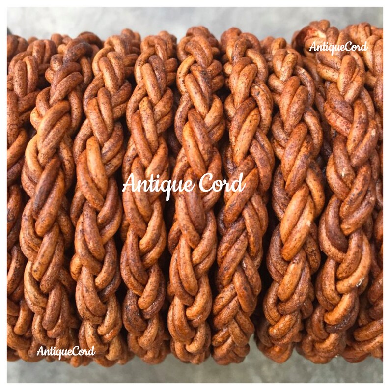 May include: Close-up of a spool of brown leather cord, braided in a complex pattern. The cord is thick and has a rustic, antique look. The text "Antique Cord" appears three times on the spool.