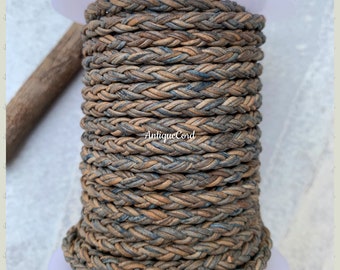 May include: A spool of braided leather cord in brown and blue tones. The cord is wound around a white spool with a label that reads "AntiqueCord".