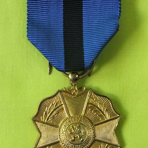 May include: A gold medal with a lion in the center and the words "UNION  FAIT LA FORCE" around it. The medal is attached to a blue ribbon with a black stripe.