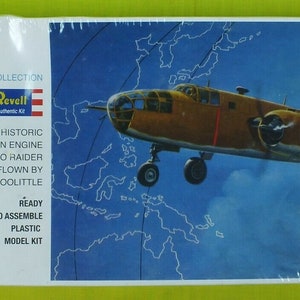 May include: A plastic model kit of a B-25 bomber airplane, part of the Pacific Raiders Collection. The box features a photo of the plane in flight over a map of the Pacific Ocean. The text on the box reads "B-25 Revell Historic Twin Engine Tokyo Raider Flown by Lt. Colonel Doolittle".