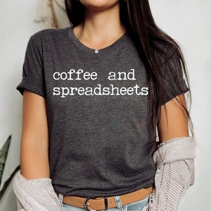 May include: A dark grey t-shirt with the text "coffee and spreadsheets" printed in white.