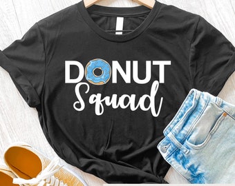 Puede incluir: Camiseta negra con texto blanco que dice "Donut Squad" y un gráfico de donut azul.