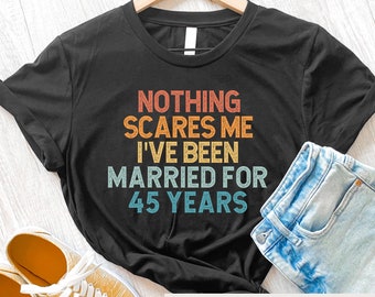 Puede incluir: Camiseta negra con un gráfico de estilo vintage que dice "NOTHING SCARES ME I'VE BEEN MARRIED FOR 45 YEARS".